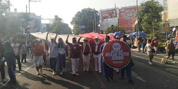 Keren! Ratusan Warga dan Pelajar Bentangkan Bendera Raksasa di CFD Solo